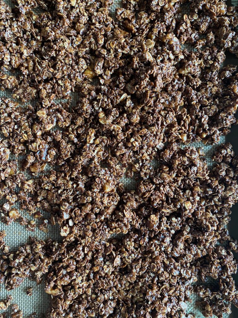 Spread granola mixture on a lined baking sheet.