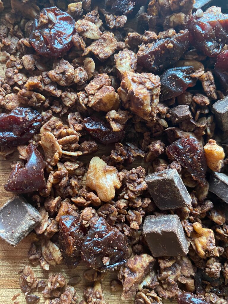 Allow the granola to cool for 10 minutes and add in the dark chocolate chunks and dried cherries.